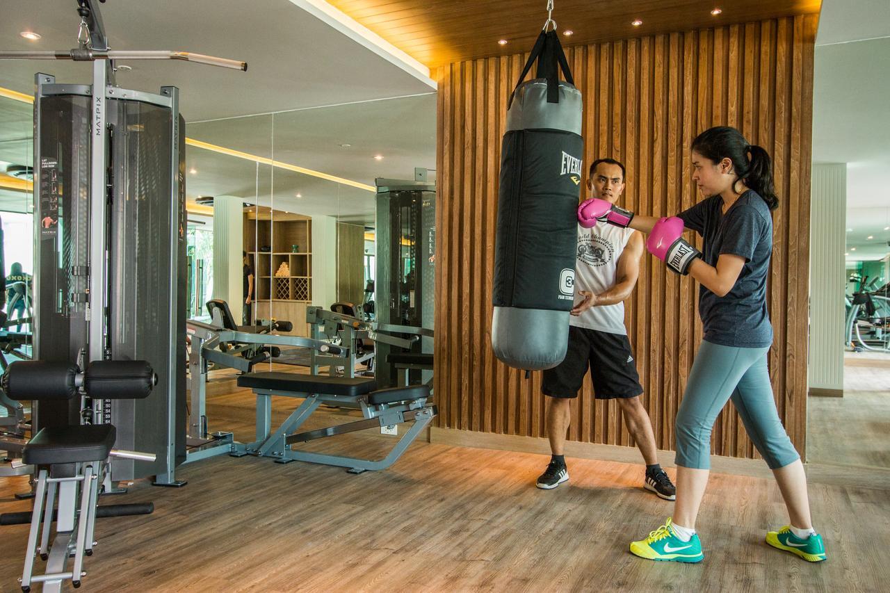Fusion Suites Phuket Patong Esterno foto A woman training with a personal trainer